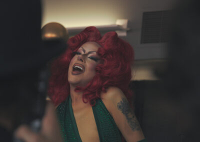Drag Queen with red hair and green dress performing