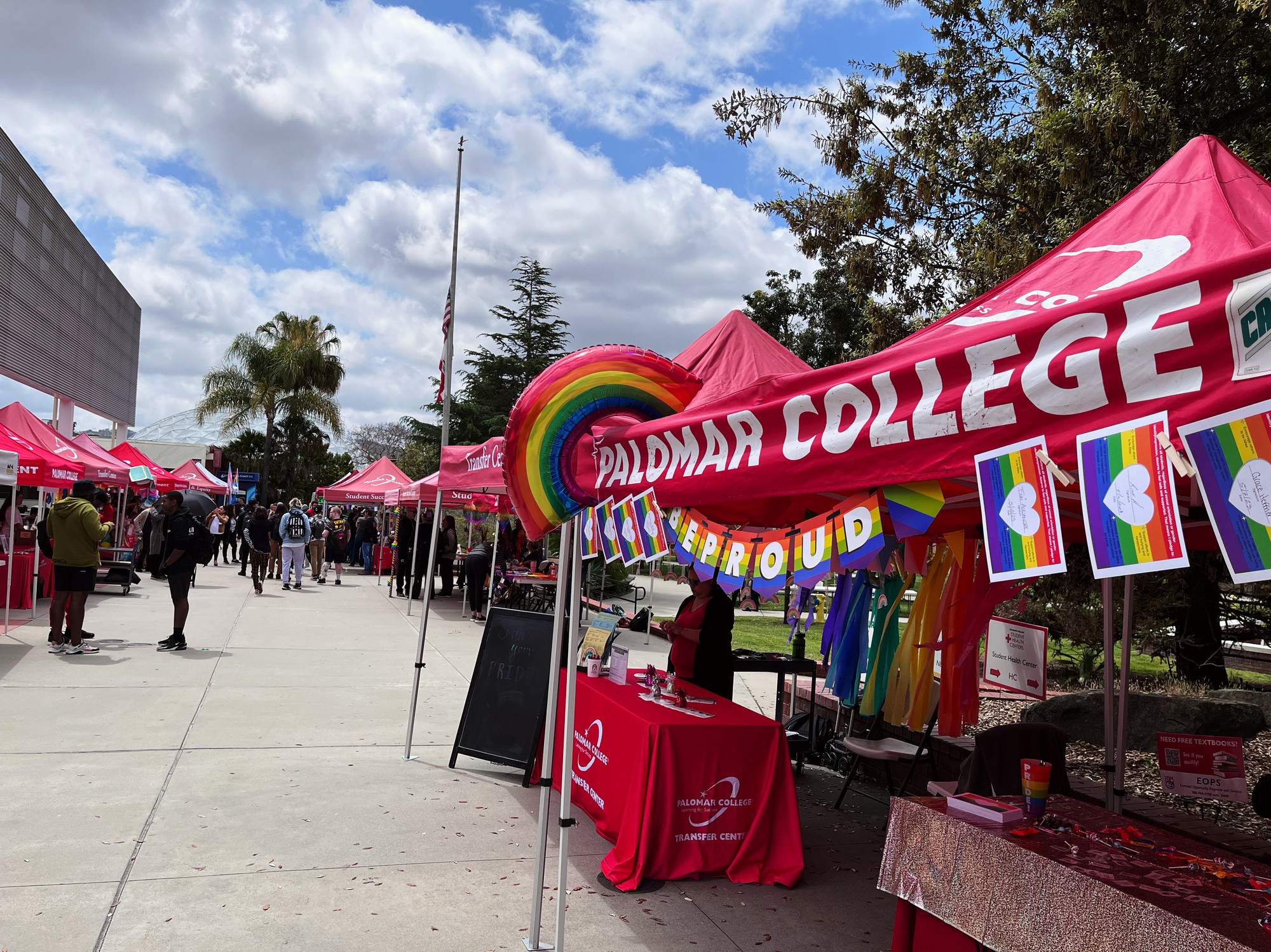A Pride booth is near the Palomar College's cafeteria as students walk by.