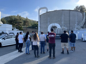 A group of students outside in front of a water technology structure.