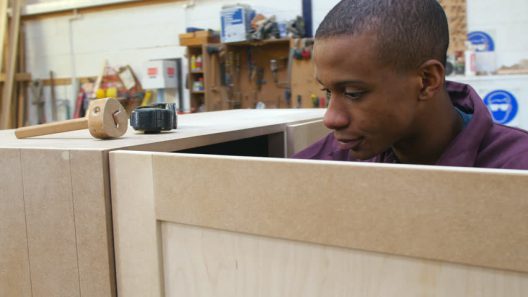 Student apprentice carpenter in a classroom woodshop setting. 