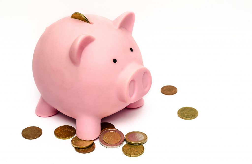 Piggy bank with coins scattered around it
