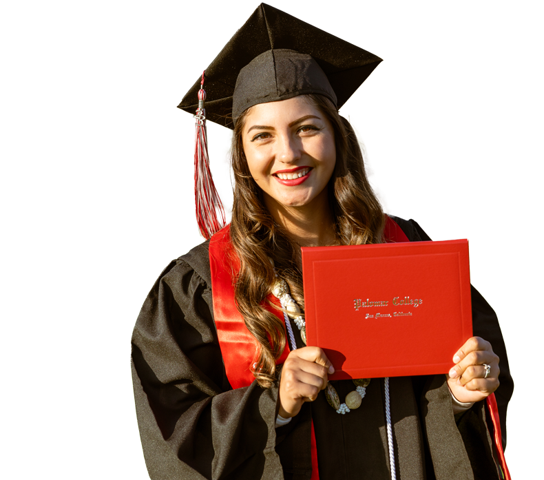 Smiling graduate holding a diploma cover.